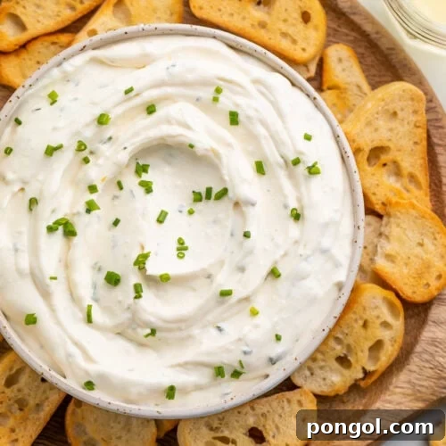 Dreamy 3-Ingredient Boursin Dip 4 Creamy Boursin dip served in a bowl, surrounded by a variety of crostini on a platter, ready for guests.