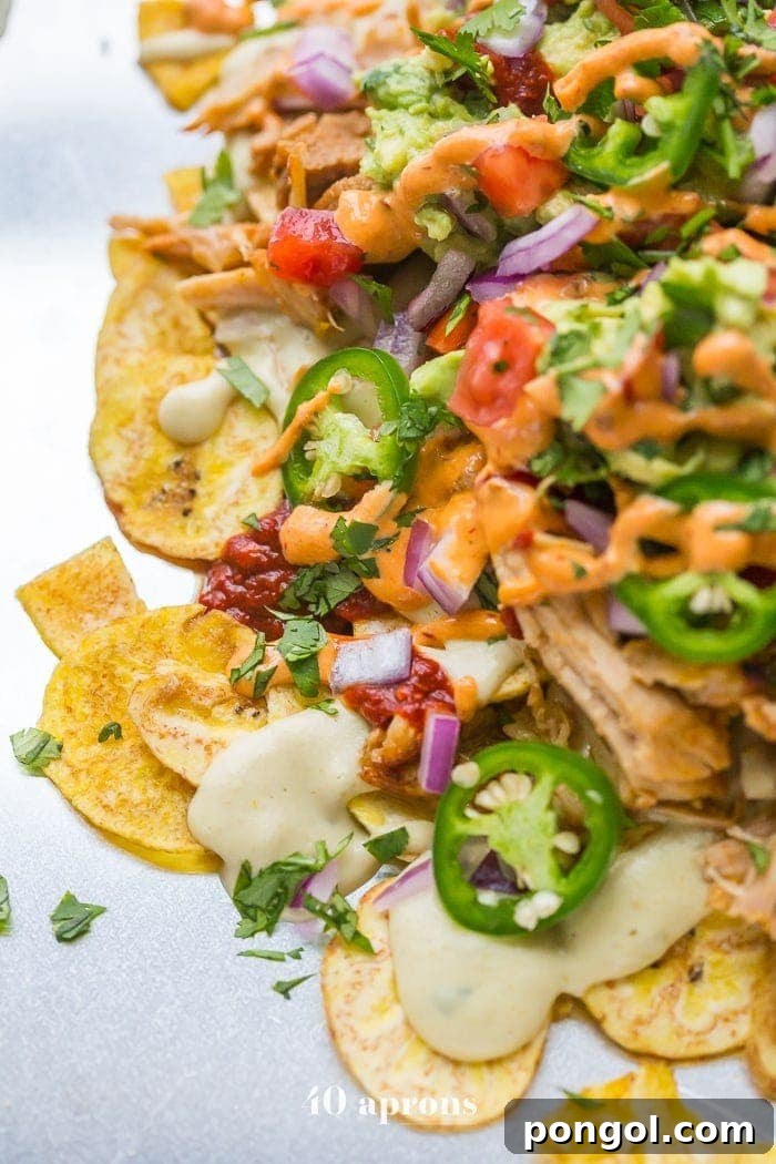 Another perspective of the epic paleo nachos, emphasizing the abundance of fresh ingredients and succulent carnitas.