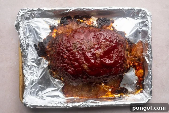 Hearty Gluten-Free Meatloaf 7 Baked gluten-free meatloaf topped with deep red ketchup glaze on a baking sheet.