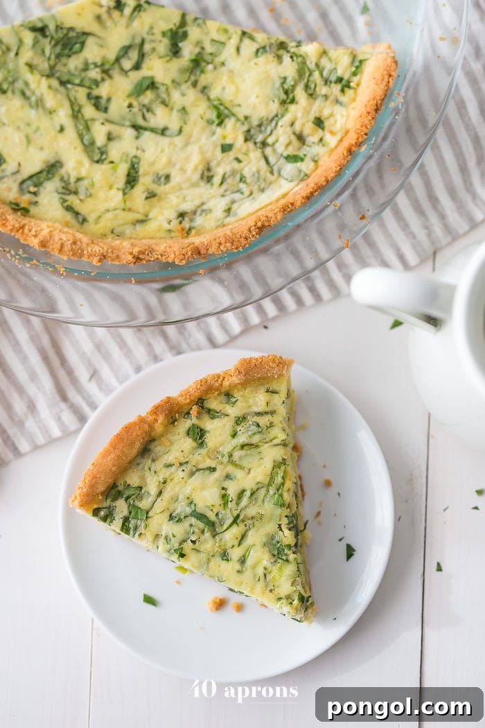 A slice of paleo crab and spinach quiche, showing its tender almond flour crust and creamy, flavorful filling. This dairy-free and gluten-free dish is perfect for a healthy brunch or light dinner, delivering gourmet taste without compromise.