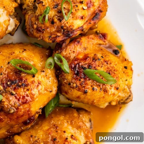 Instant Pot chicken adobo on a large white plate, garnished with sliced green onions.