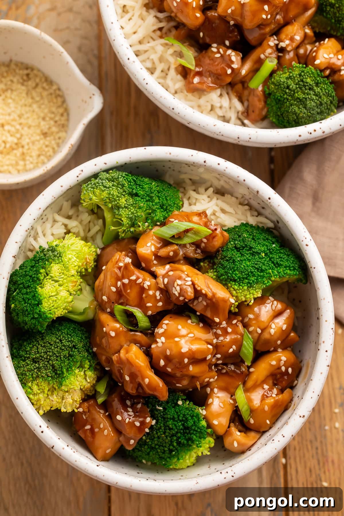 Overhead look at a white bowl holding Instant Pot chicken teriyaki with bright green broccoli and steamed white rice.