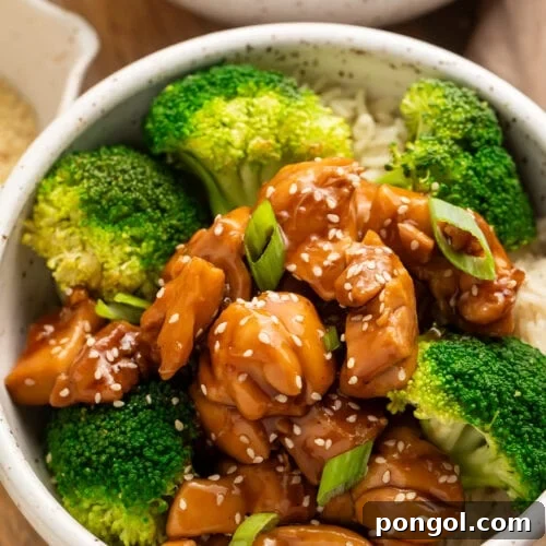 Angled side view of a bowl of Instant Pot chicken teriyaki with steamed broccoli on a bed of white rice.