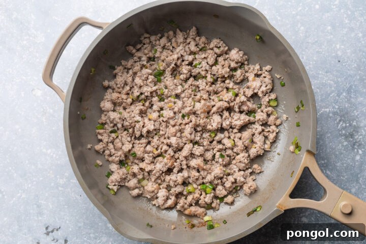 Ground pork, green onions, and ginger in a large skillet.