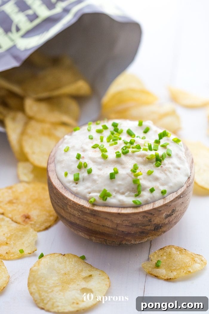 A bowl of creamy Paleo French Onion Dip surrounded by Kettle Brand Avocado Oil Potato Chips.