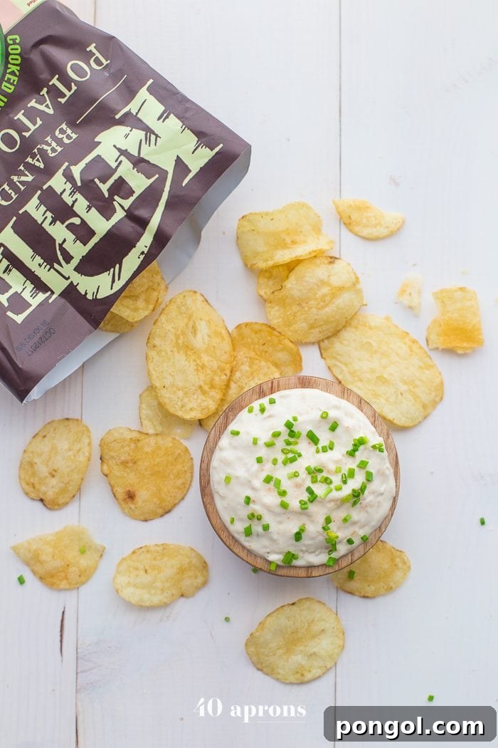 Overhead shot of Paleo French Onion Dip and Kettle Brand Avocado Oil Potato Chips on a cutting board, perfect for a summer snack.