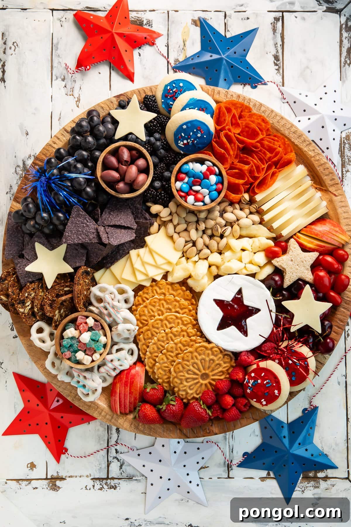 Overhead photo of a festive 4th of July, red-white-and-blue themed charcuterie board on a table, a perfect pairing for paleo cocktails.