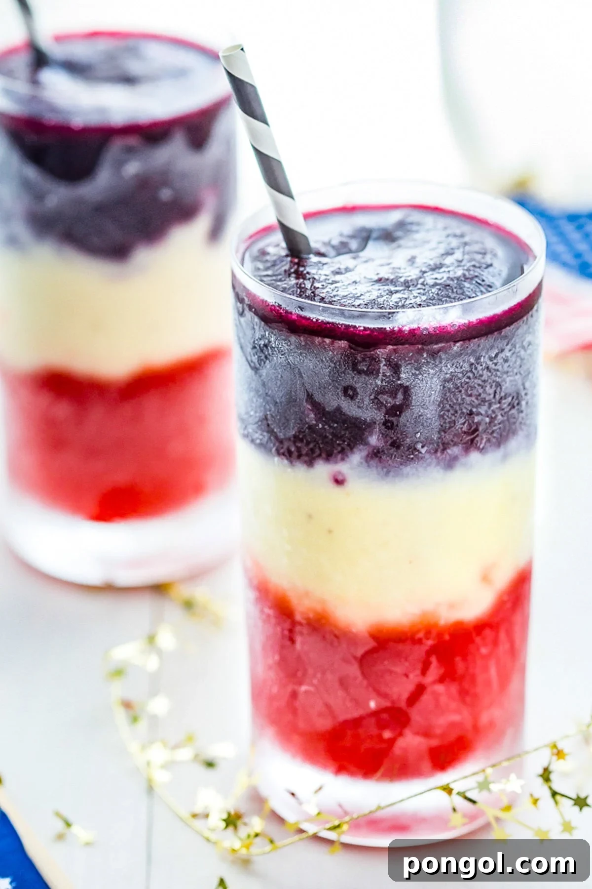 Close-up of the red and white layers of a paleo cocktail, showing the distinct separation and fruity texture.