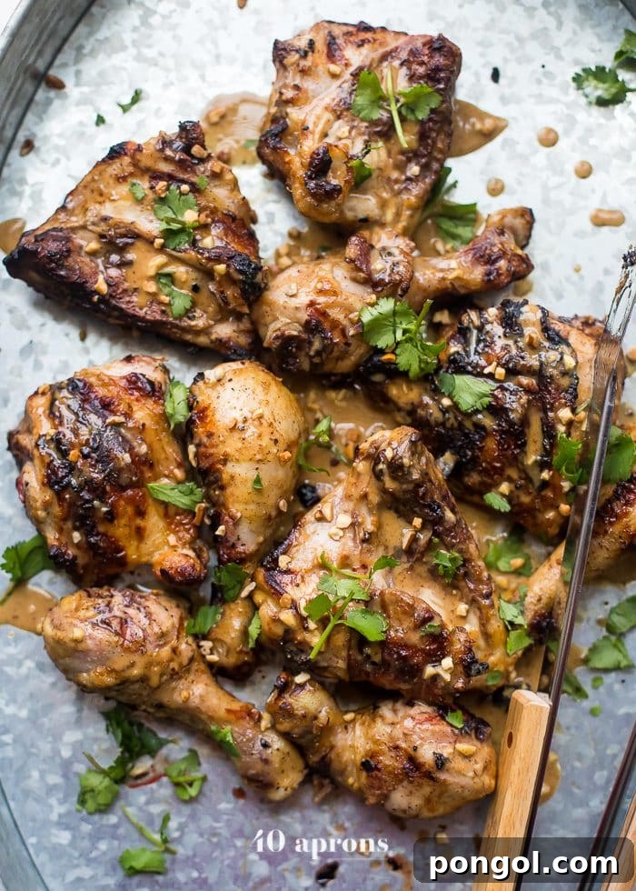 A close-up of grilled chicken satay, beautifully charred and tender, served with a vibrant dipping sauce.