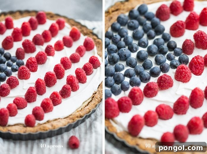 A close-up of the delicate fruit arrangement on a Paleo Flag Fruit Tart, with juicy red raspberries and plump blue blueberries creating a festive flag design.