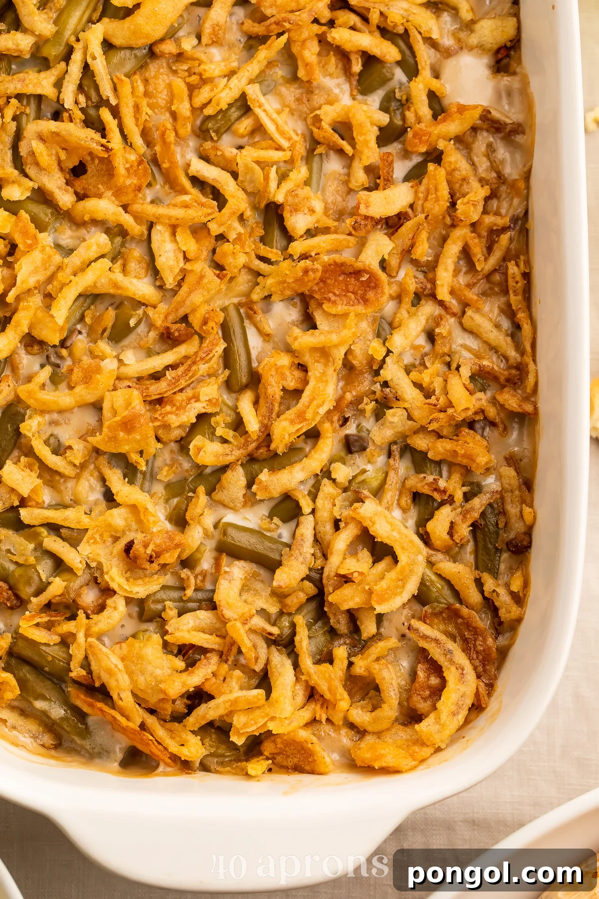 30 Festive Casseroles Your Holiday Table Needs 13 Overhead view of a large rounded rectangular casserole dish holding a make-ahead green bean casserole.