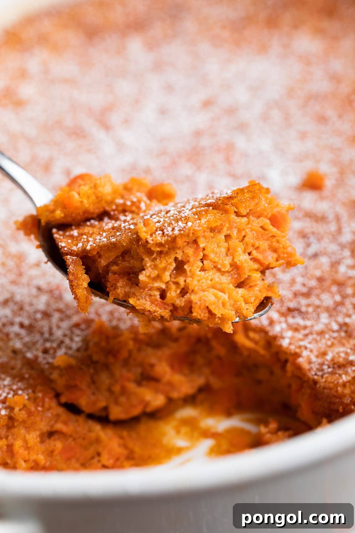 30 Festive Casseroles Your Holiday Table Needs 18 A spoonful of carrot soufflé being lifted out of a casserole dish