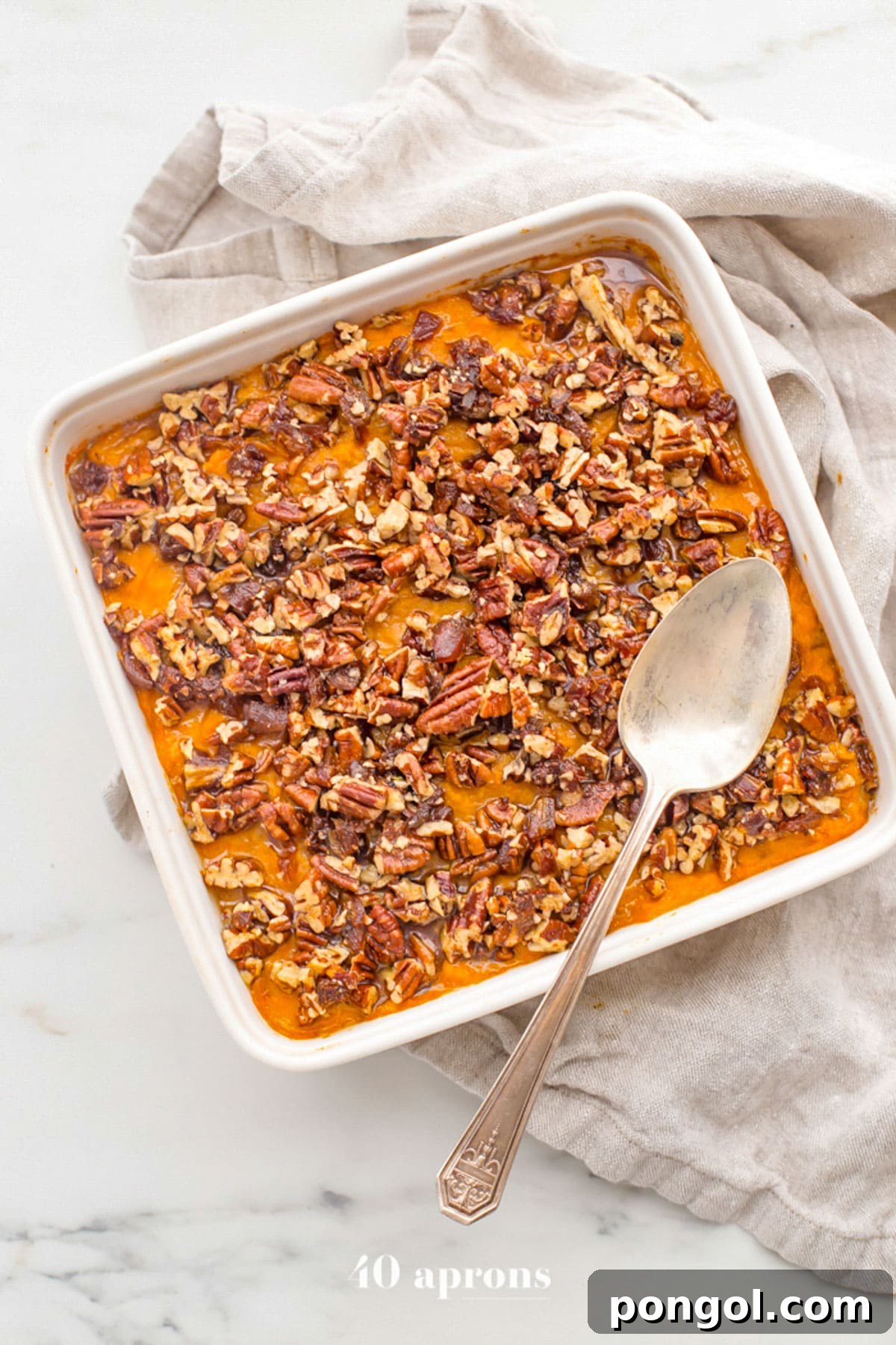 30 Festive Casseroles Your Holiday Table Needs 21 Overhead view of a square casserole dish holding a Whole30 sweet potato casserole topped with pecans.
