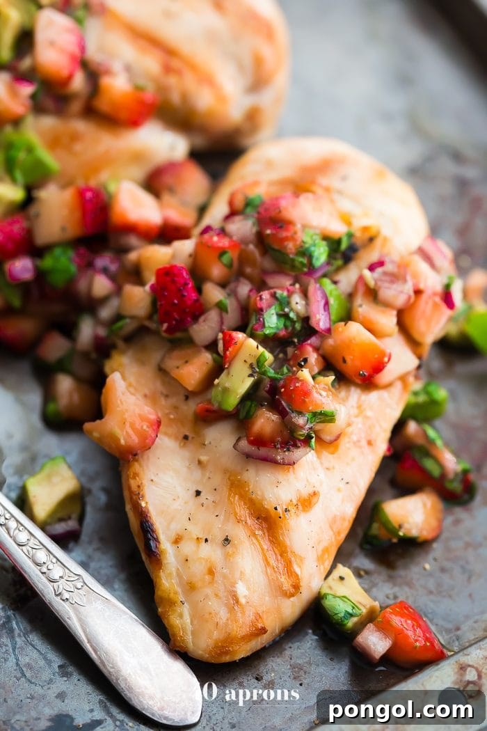 Overhead shot of grilled Whole30 chicken breasts topped with fresh strawberry basil avocado salsa
