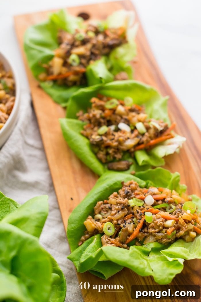 A close-up shot of healthy PF Changs style lettuce wraps presented on a rustic wooden board, ready to be enjoyed.