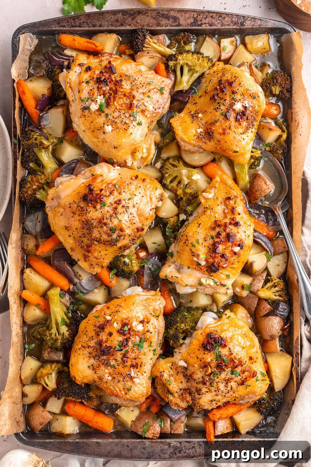 Flavorful One-Pan Chicken Dinner 2 Golden-brown, succulent chicken thighs roasted with colorful mixed vegetables on a single sheet pan, drizzled with garlic butter sauce.