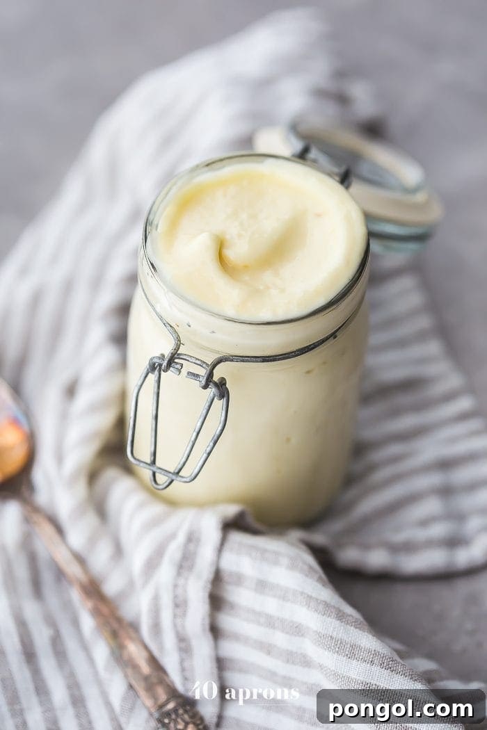 Freshly made Whole30 mayonnaise in a glass jar, ready for use.