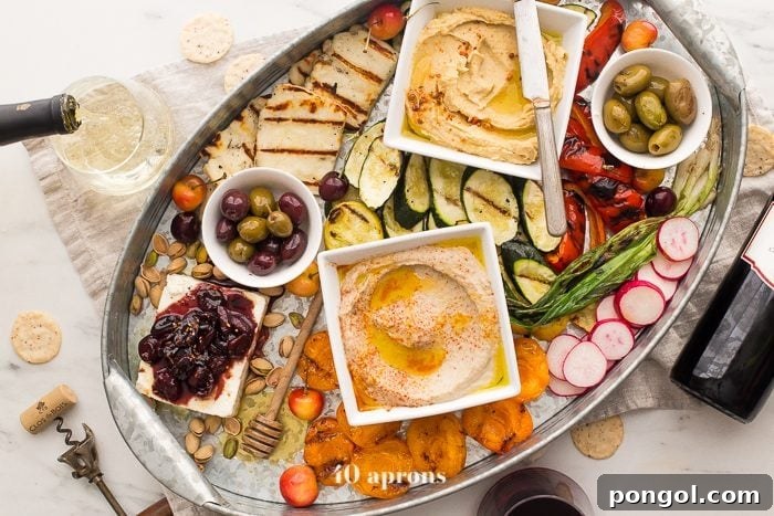 Overhead shot of a healthy Greek appetizer platter with emphasis on the feta and balsamic-vanilla bean cherries
