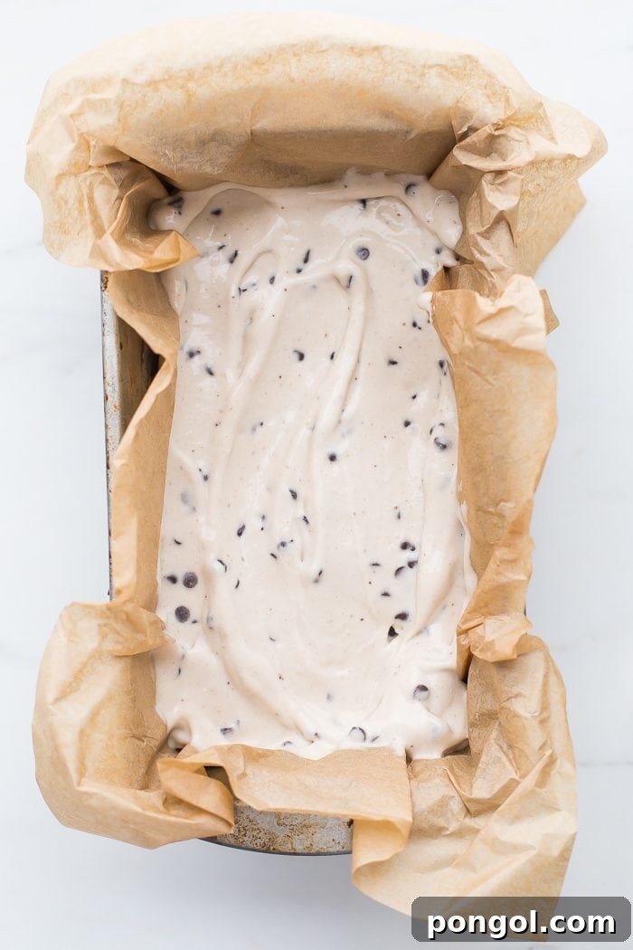 A close-up view of a hand holding a healthy vegan ice cream sandwich, highlighting its delicious layers.