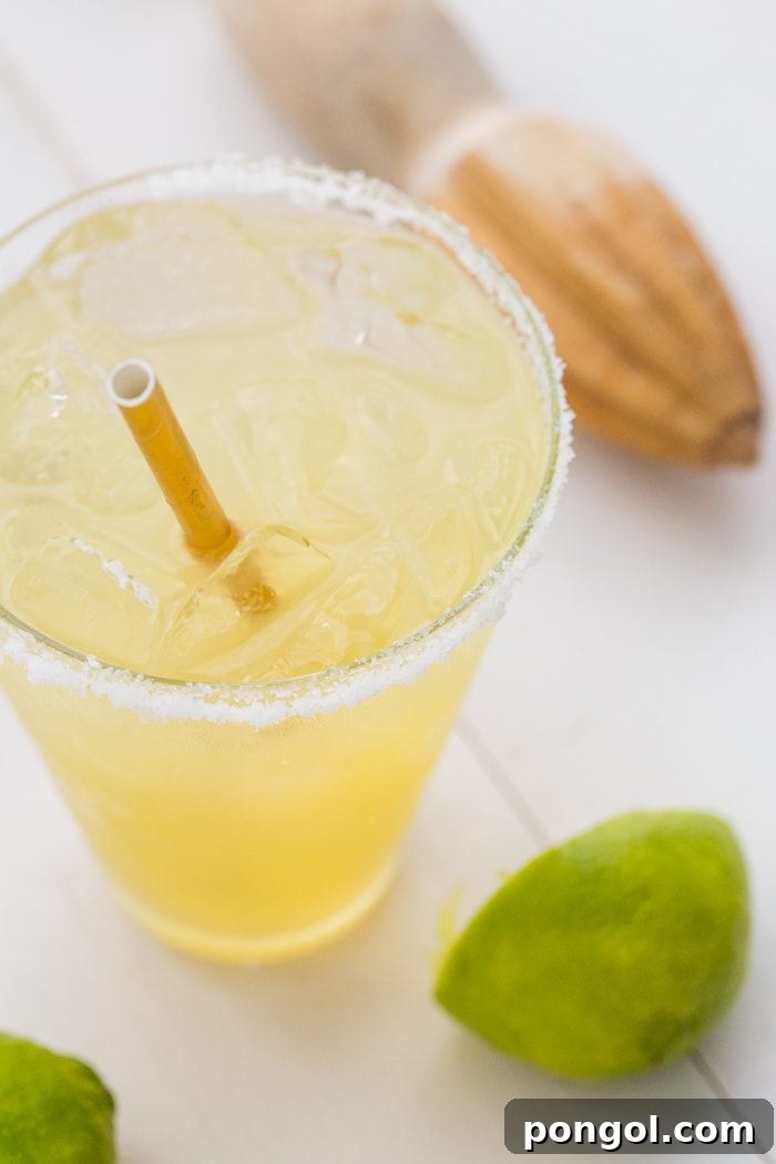 Another close-up shot of the Paleo Margarita with Champagne, showing the bubbly texture and fresh lime garnish.