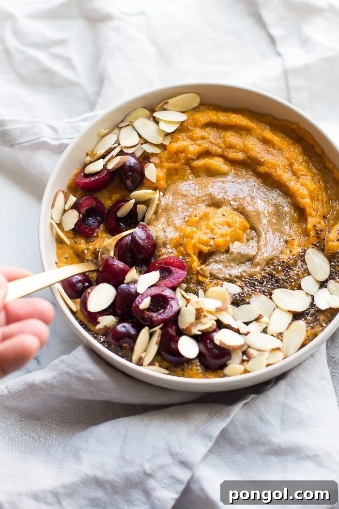 A close-up shot of the creamy sweet potato Whole30 breakfast bowl, garnished with colorful fresh fruit and a drizzle of nut butter. The inviting texture and natural hues promise a delightful and healthy start to the day, packed with essential nutrients for sustained energy.