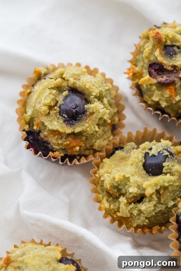 Freshly baked gluten-free blueberry avocado muffins cooling on a wire rack, showcasing their perfect dome shape.