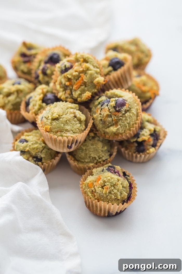 A stack of gluten-free blueberry avocado muffins on a rustic wooden board, ready for breakfast or snack time.