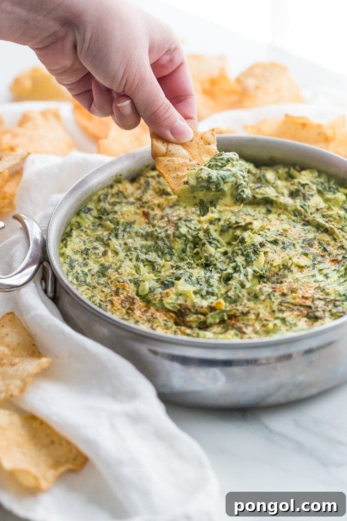 Creamy Paleo Vegan Spinach Artichoke Dip 3 Close-up of a spoonful of creamy vegan spinach artichoke dip
