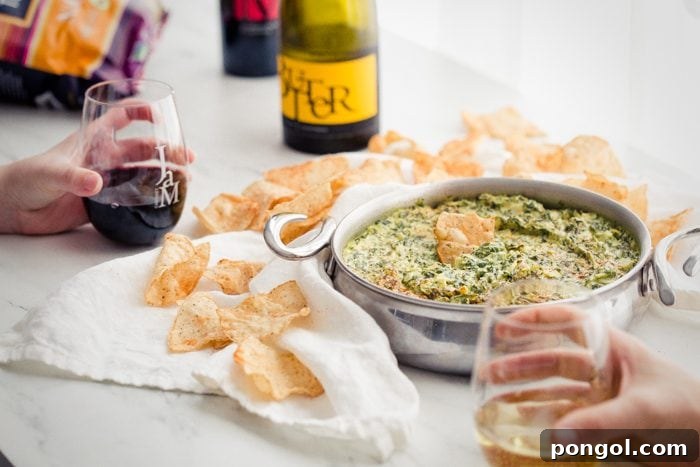 Creamy Paleo Vegan Spinach Artichoke Dip 4 Table spread with paleo spinach artichoke dip, chips, and JaM Cellars wine bottles