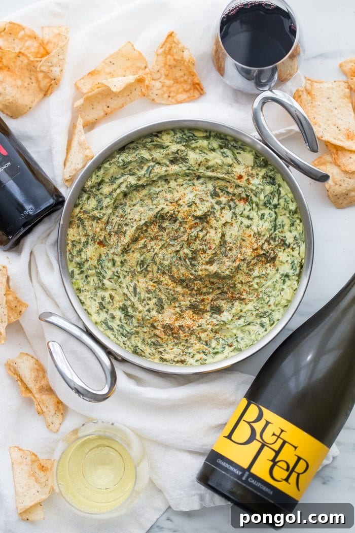 Creamy Paleo Vegan Spinach Artichoke Dip 9 An overhead shot of the paleo spinach artichoke dip with chips and fresh herbs