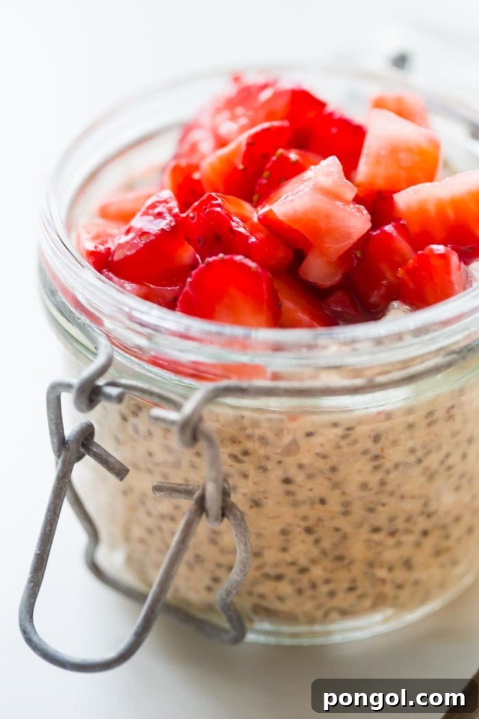 Another perspective of the PB&J chia pudding in a jar, highlighting the smooth texture of the pudding and the vibrant color of the strawberry topping, a perfect paleo breakfast.