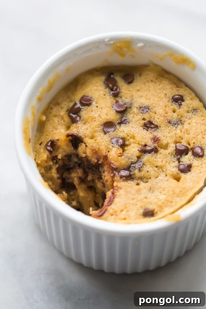 Overhead shot of the paleo microwave cookie, perfectly golden brown and speckled with chocolate chips, ready to be eaten.