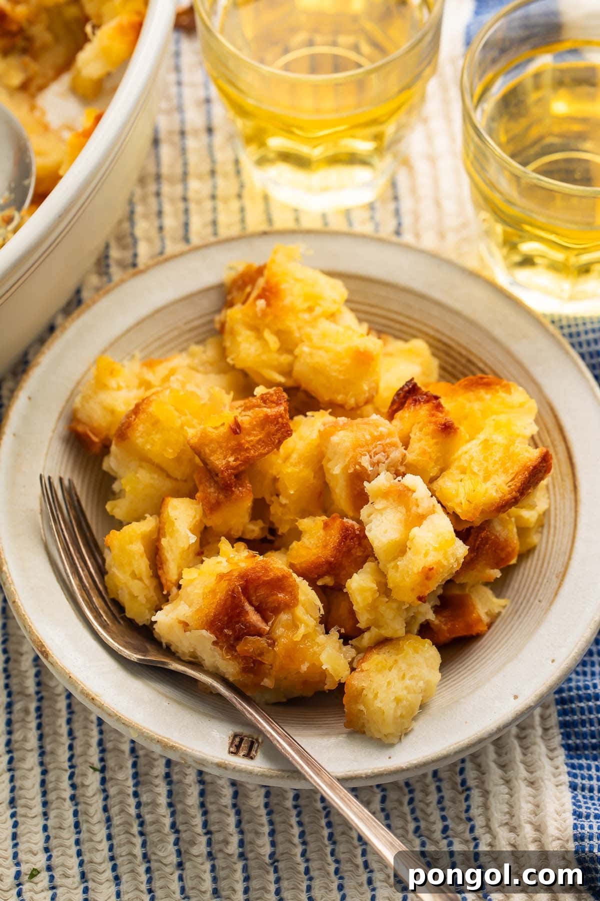 Tropical Pineapple Stuffing 2 A bowl of pineapple stuffing resting on a table next to a baking dish.