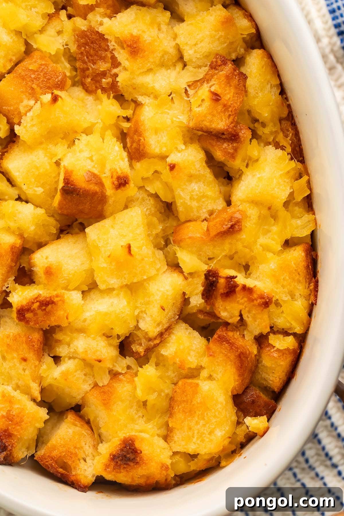 Tropical Pineapple Stuffing 4 A close-up of pineapple stuffing in a large white oval ceramic baking dish.