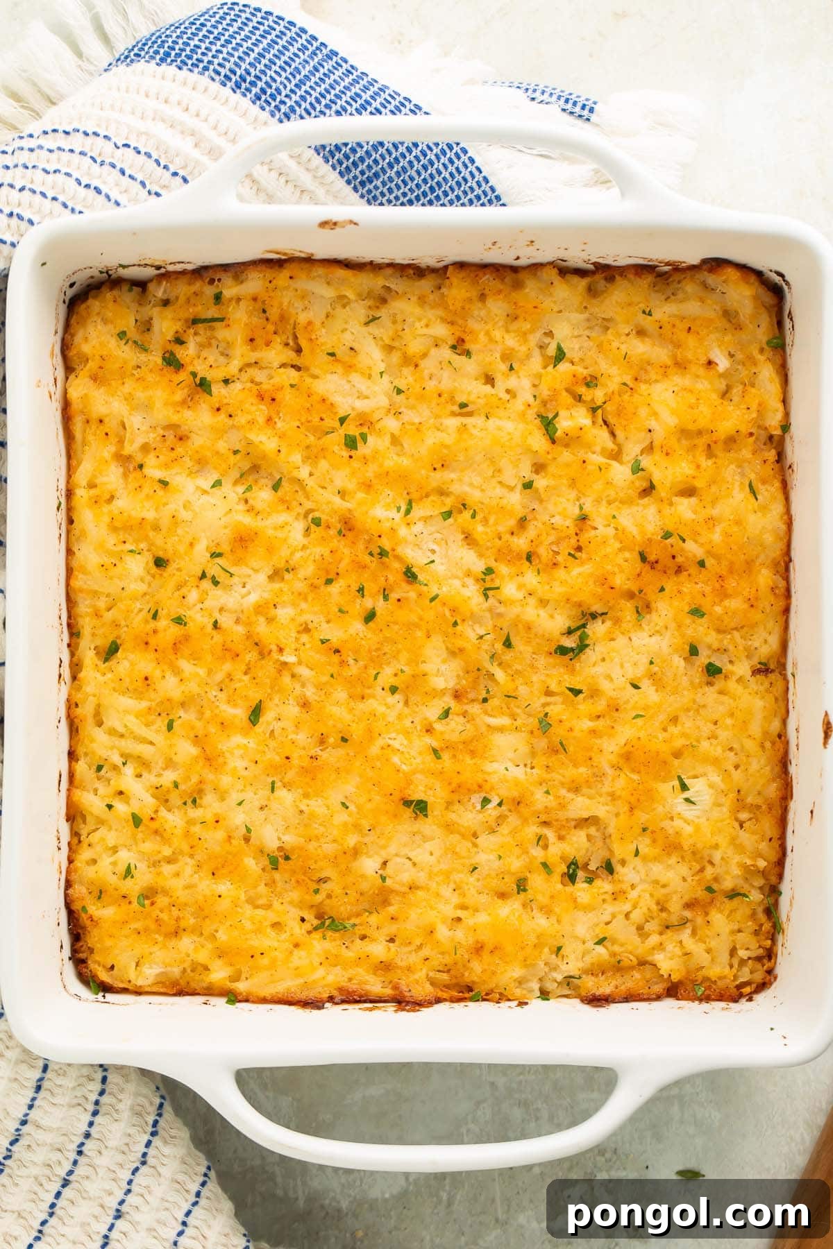 Overhead photo of a full, freshly baked cheesy potato casserole dish, golden and bubbly, ready for serving.