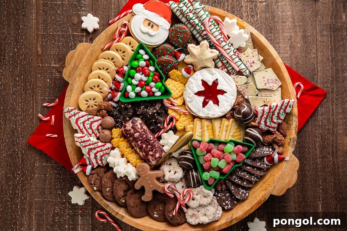 A Christmas dessert themed grazing board, packed full with Christmas tree cakes, brie, goat cheese, crackers, pretzels, truffles, nuts, cookies, and other holiday-themed treats.