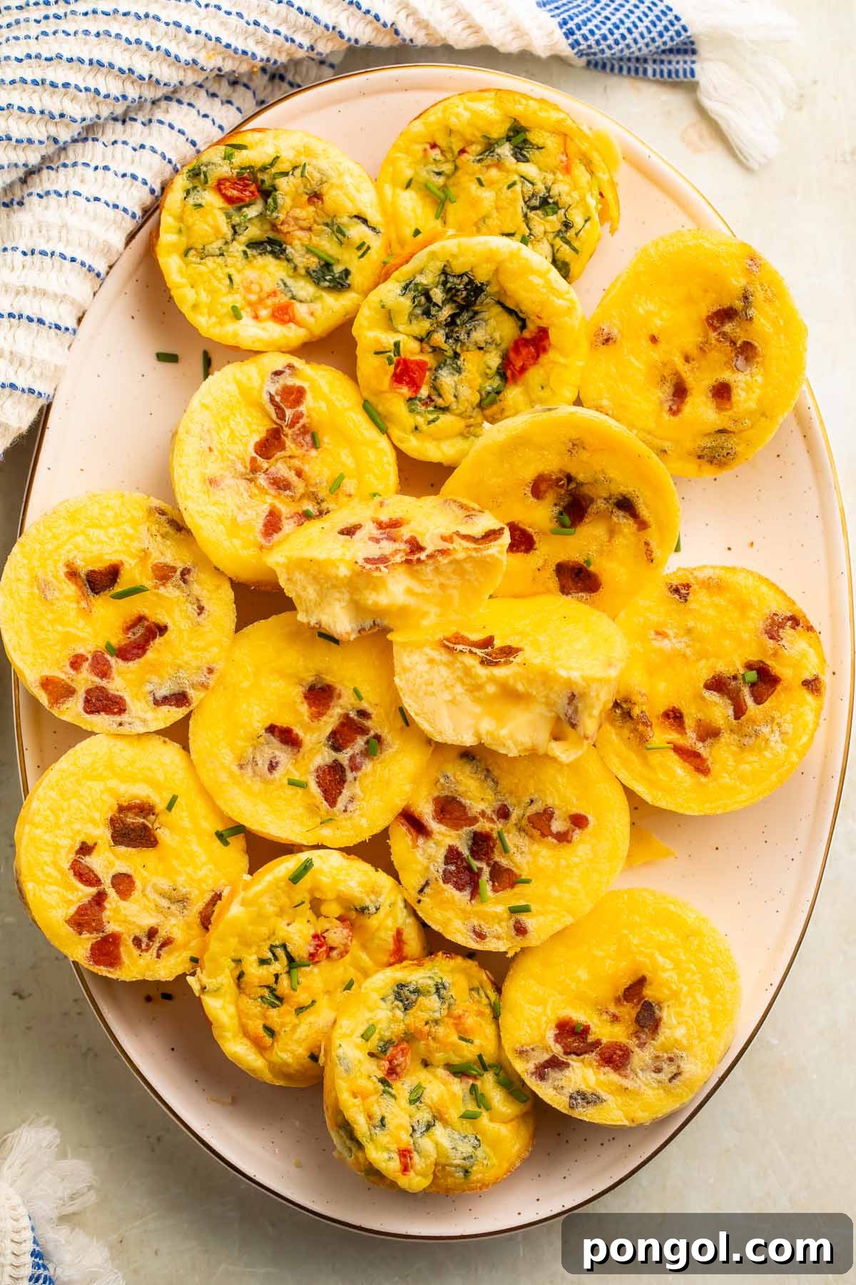 An oval platter with muffin-shaped egg bites made with cottage cheese, crispy bacon, and finely chopped colorful vegetables, ready for a healthy breakfast.