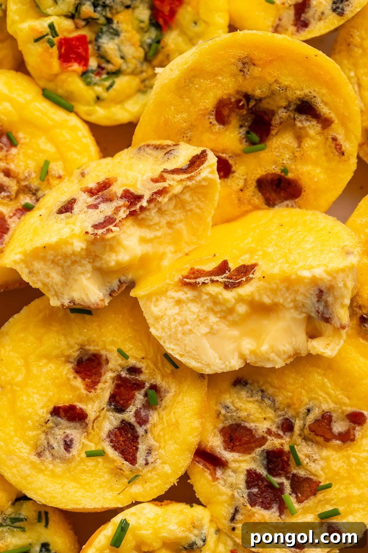 Close-up of fluffy, muffin-shaped egg bites made with cottage cheese, generously studded with chopped bacon and vibrant mix-ins, presented enticingly.
