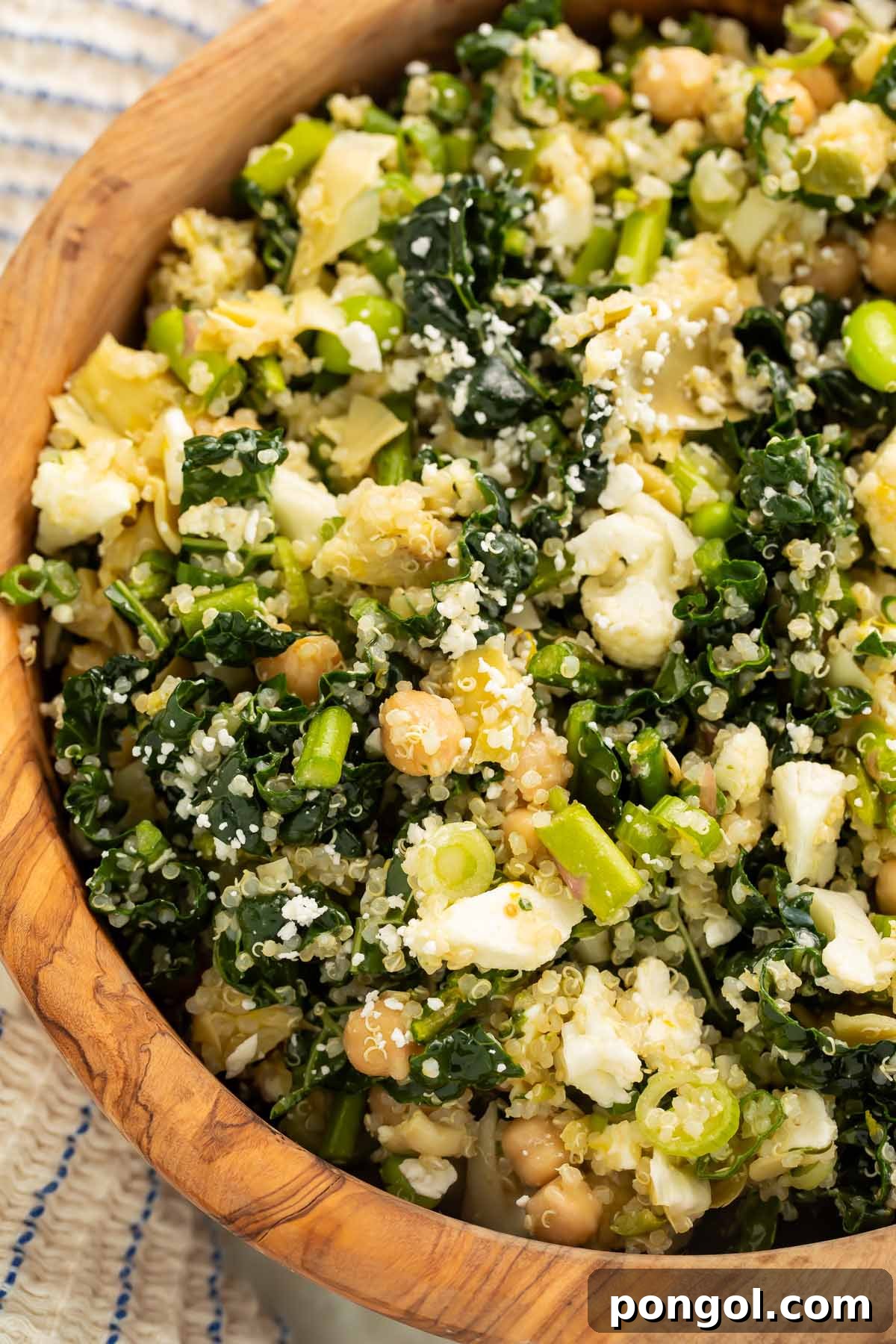 A vibrant and fully mixed bowl of the detox salad, featuring prominent chickpeas, quinoa, feta, and a colorful array of vegetables.