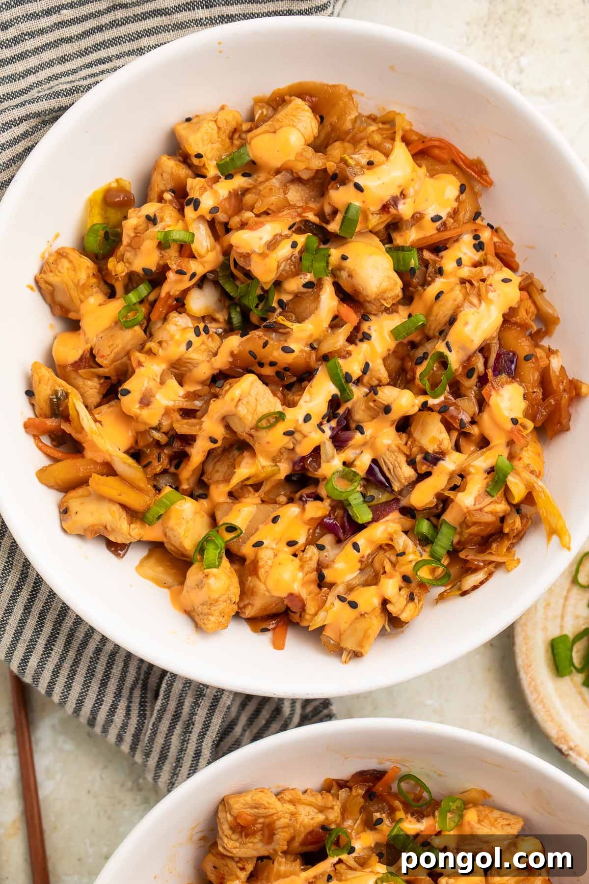 Close-up of chicken egg roll in a bowl on a table, showing the texture and garnishes.