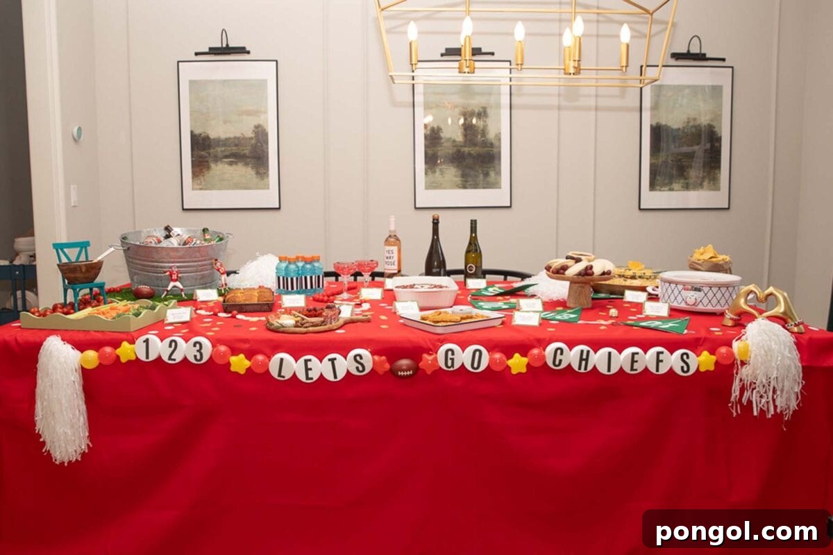 Dining room table, fully decorated with Taylor Swift Super Bowl decorations and food. A bracelet garland across the front of the table reads 