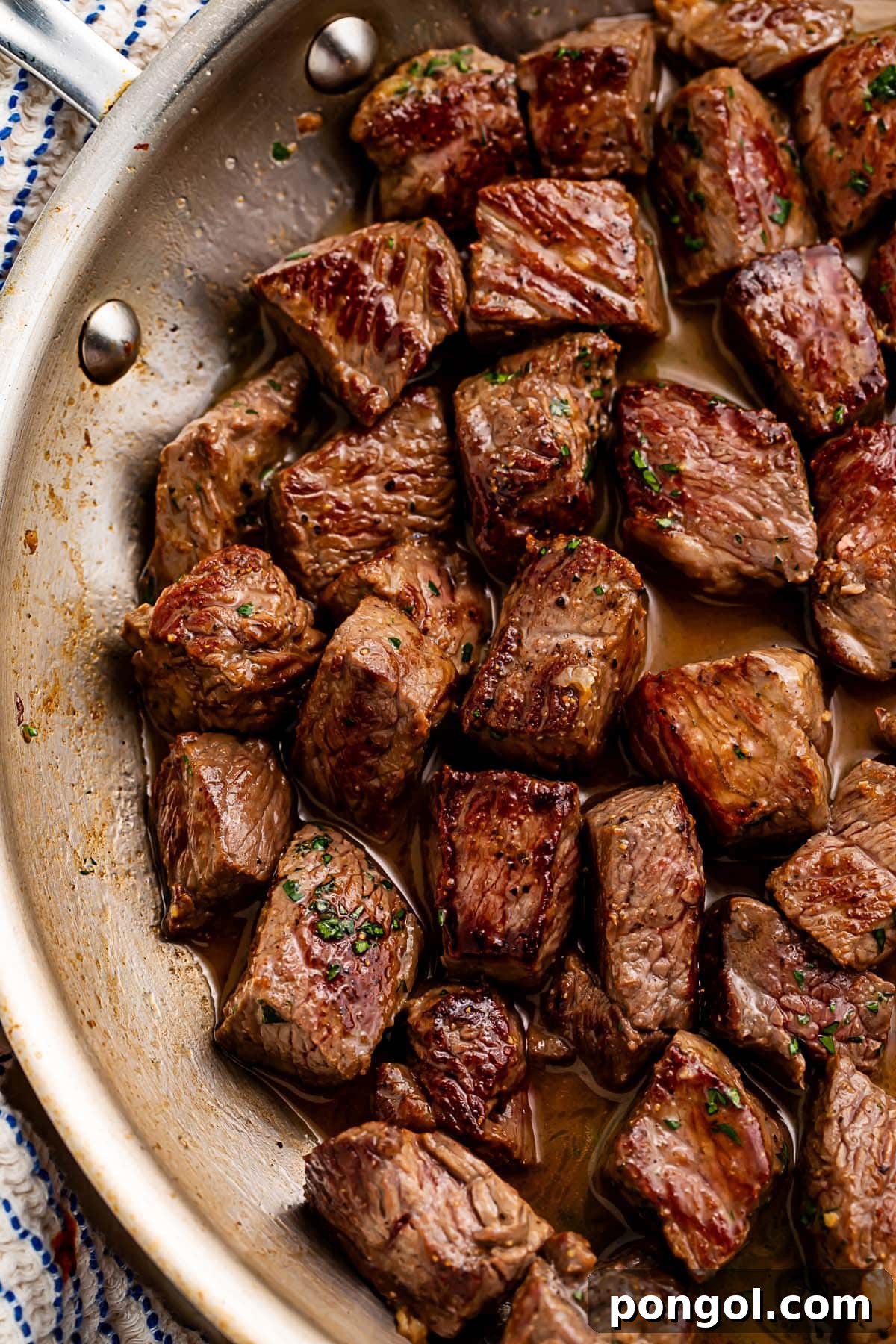 Gorgeous rich garlic butter steak bites in a large skillet, ready to be served.