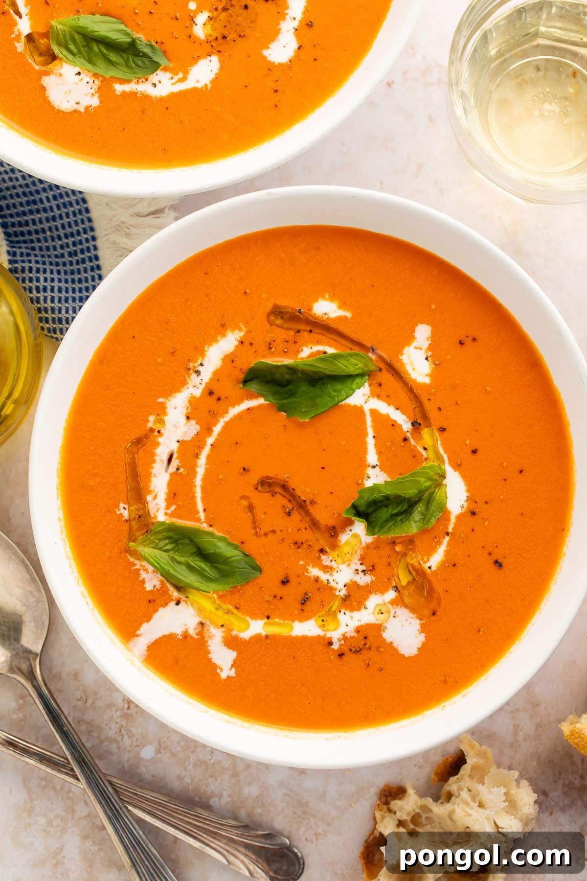Effortless Instant Pot Tomato Perfection 2 Two bowls of orange tomato soup with cream swirls and fresh herbs