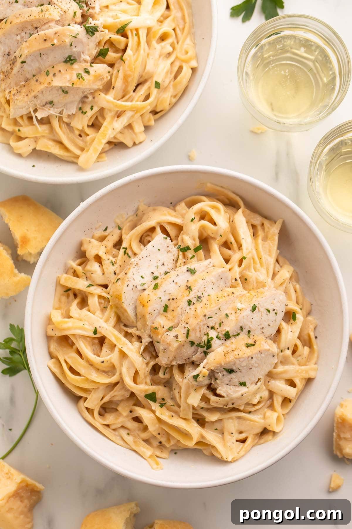 Speedy Creamy Instant Pot Chicken Alfredo 2 Overhead photo of a large white bowl holding chicken alfredo cooked in an Instant Pot, garnished with fresh parsley.
