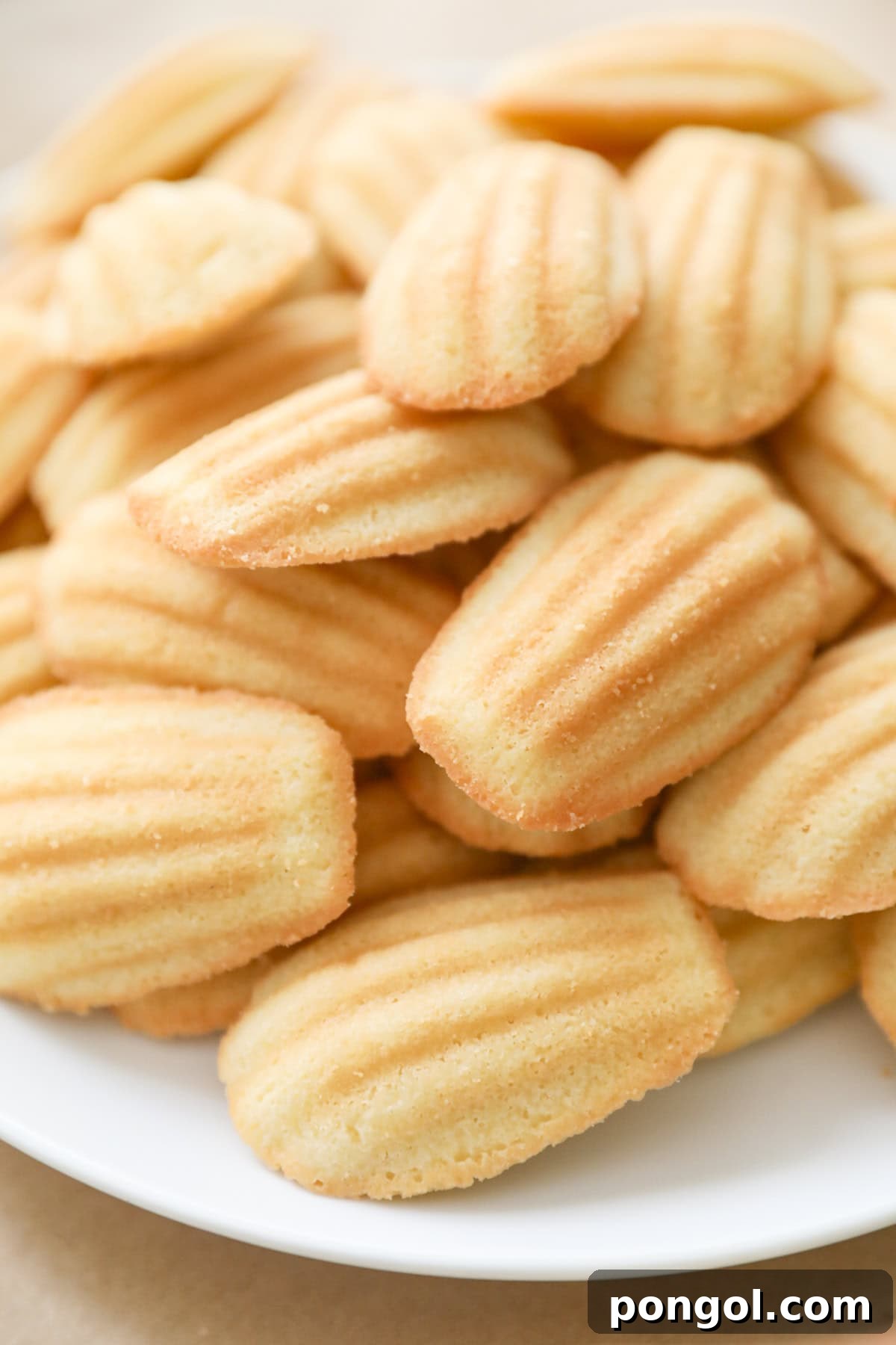 Soft Madeleine cookies from Costco arranged on a white platter.