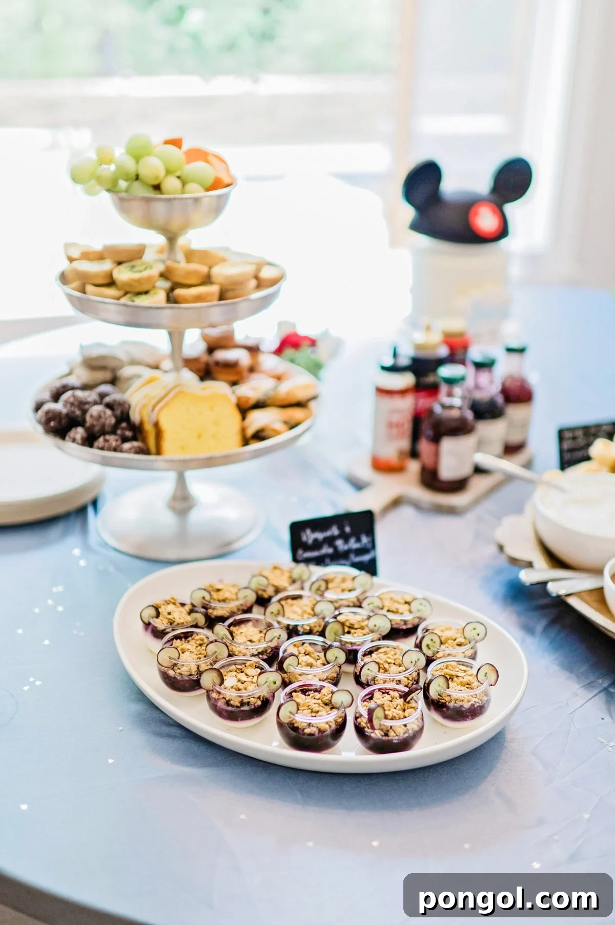 Brunch foods on platters and tiered trays for a Magic Kingdom birthday party.