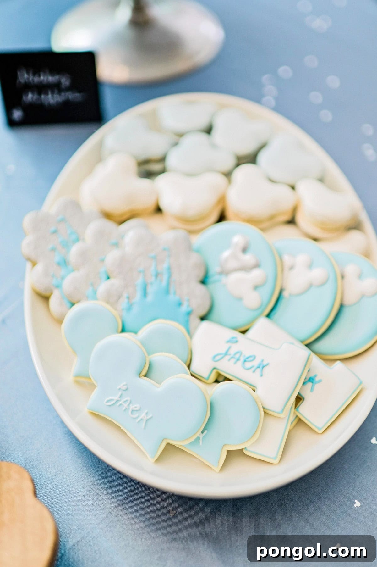 A platter of light blue, silver, and white decorated cookies and macarons.