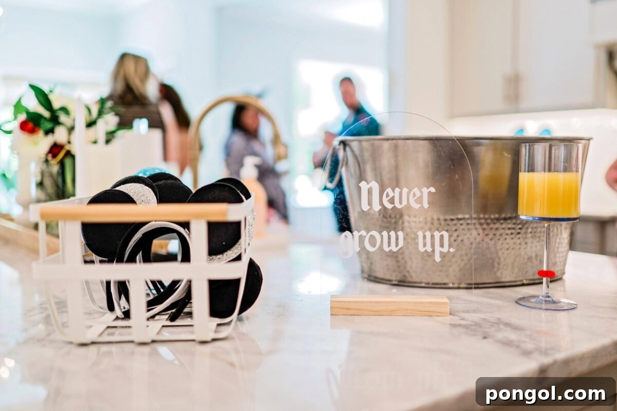 An acrylic "Never Grow Up" sign sits on a countertop next to a basket of mouse ear headbands.
