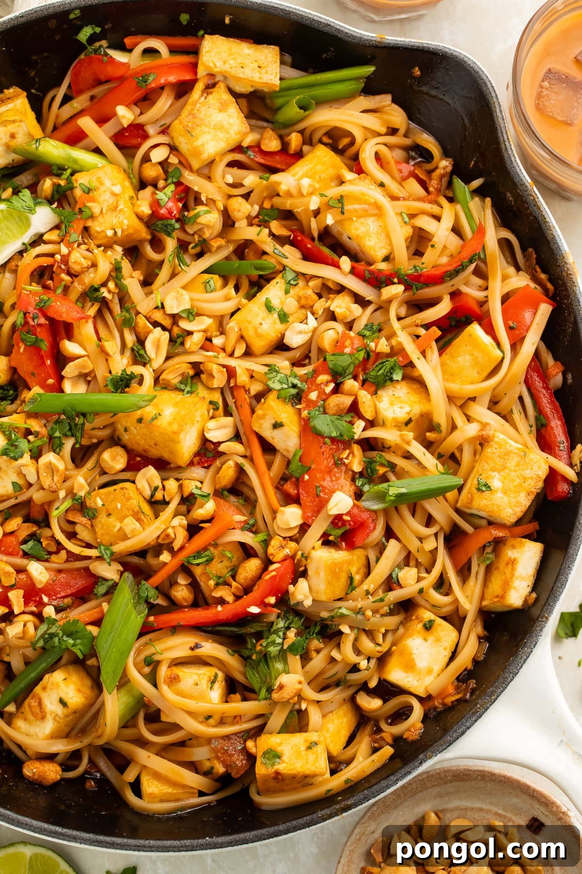 A large skillet filled with freshly cooked vegan pad thai, showcasing its vibrant ingredients.