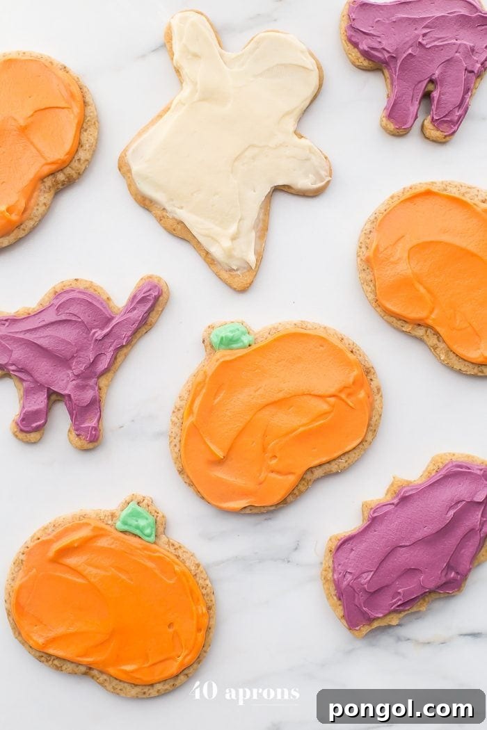 Delicious paleo Halloween cookies decorated as pumpkins and ghosts, laid out on a table, ready to be enjoyed.